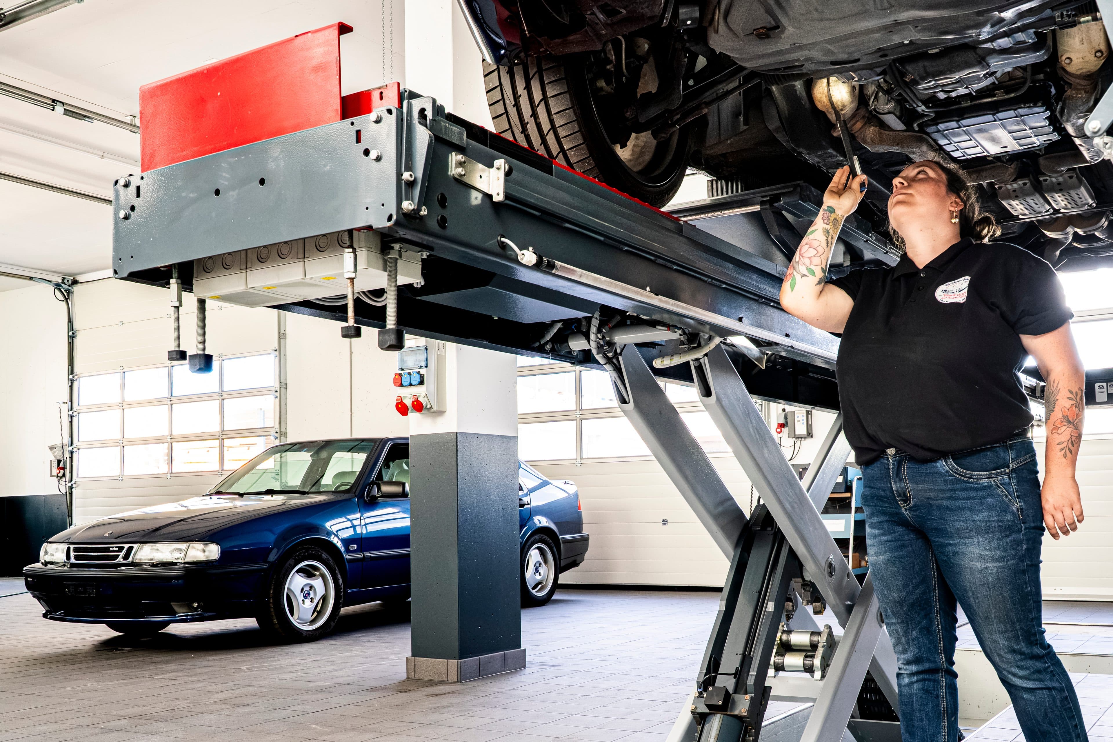 Kontrolle eines angehobenen Fahrzeugs von unten auf der Hebebühne