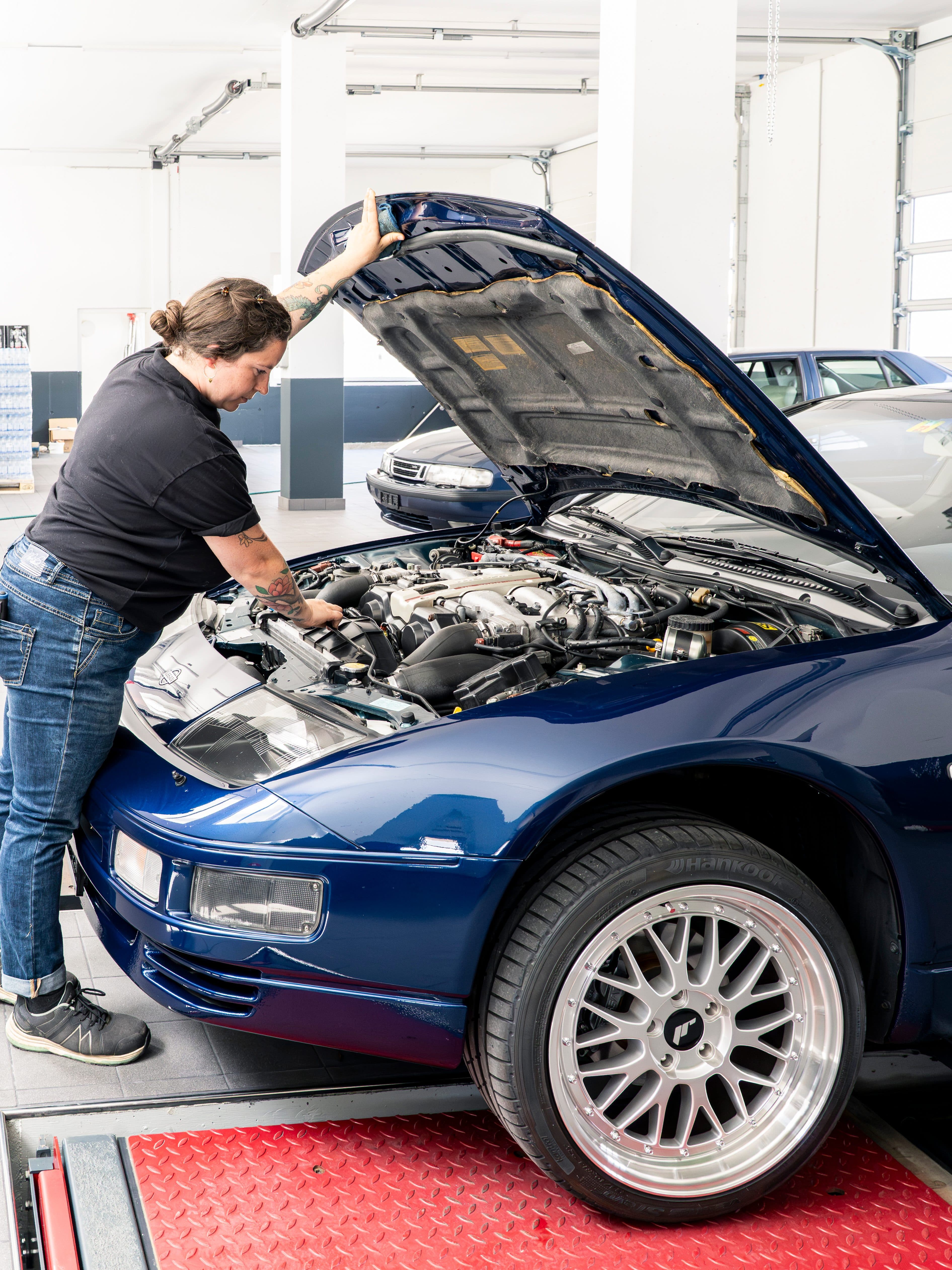 Arbeit am geöffneten Motorraum eines Fahrzeugs in der Werkstatt