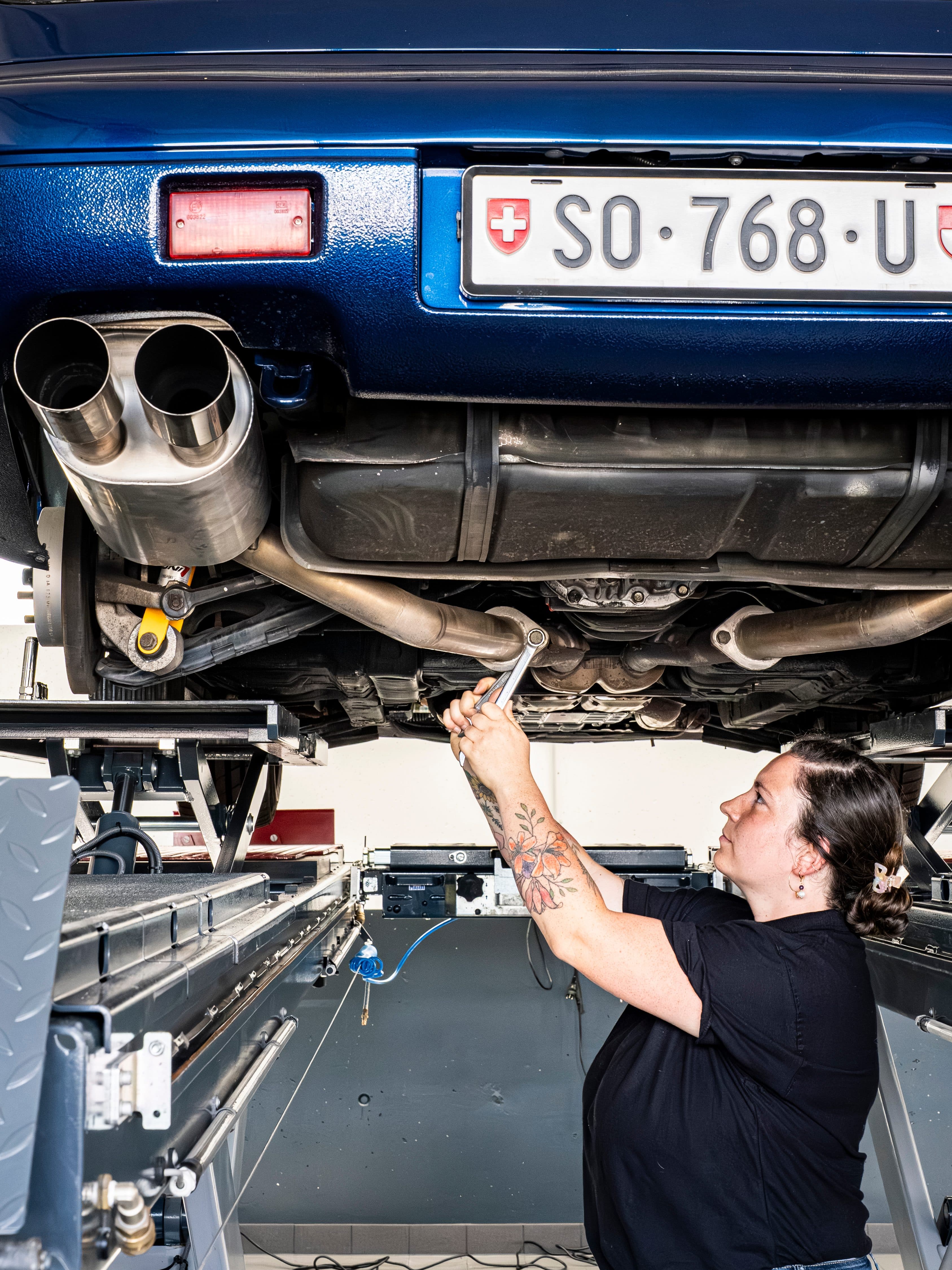 Arbeit an der Auspuffanlage eines Fahrzeugs von unten